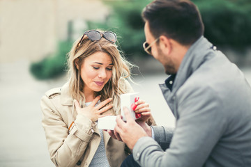 couple in love.man surprising his girlfriend with a gift.