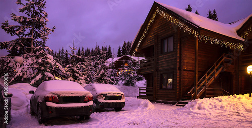 Fototapeta A fairy-tale house in the woods amid the snow-covered fir trees, Christmas landscape