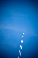 Wall Mural - plane isolated flying high above in blue sky, travel concept