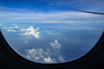Wall Mural - flying on the plane seeing sunrise light on abstract white cloud and shades of blue sky background w