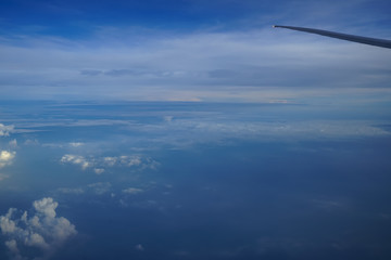 Wall Mural - flying on the plane seeing beautiful shades of tinted blue sky horizon background and sunrise light 
