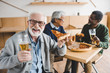 © LIGHTFIELD STUDIOS - senior man eating pizza with beer