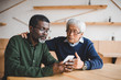 © LIGHTFIELD STUDIOS - senior friends looking at smartphone