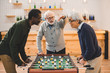© LIGHTFIELD STUDIOS - senior friends playing table football