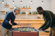 © LIGHTFIELD STUDIOS - senior friends playing table football