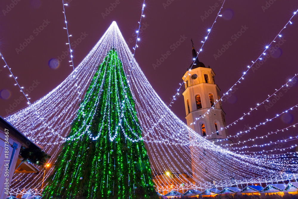 Obraz na płótnie Decorated and illuminated Christmas tree on the Cathedral Square and Cathedral Belfry at night, Vilnius, Lithuania, Baltic states. w salonie