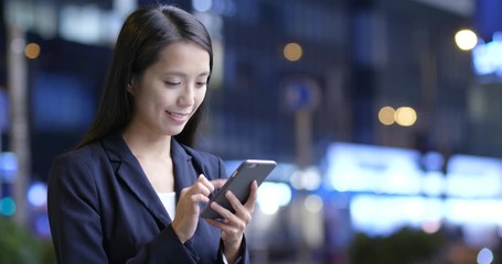 Wall Mural - Businesswoman use of cellphone in city