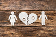 paper family near a broken heart a divorce on a wooden background