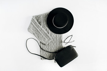 Wall Mural - Minimal woman fashion winter clothes look on white background. Hat, sweater, purse and glasses. Flat lay, top view.