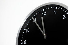Five To Midnight Or Noon On The Black Wall Clock Against White Background