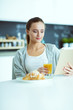 © lenets_tan - Young woman with orange juice and tablet in kitchen.