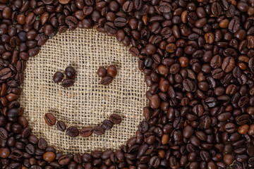 Wall Mural - Coffee beans in shape of smile on sackcloth 