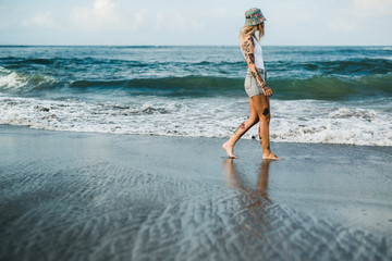 Tattooed woman walking at beach