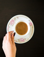 Wall Mural - Top View Woman's Hand Holding Coffee Cup on Table