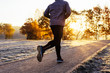 © baranq - Close-up of man jogging on sunny autumn morning outdoors