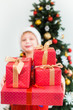 © Andrii Oleksiienko - Portrait of cute funny little kid dressed in red night pajamas and hat of santa. Blurry white happy kid holding pile of holiday presents in hands and smiles happily. Focus at foregraund.