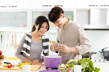 young asian couple cooking in kitchen