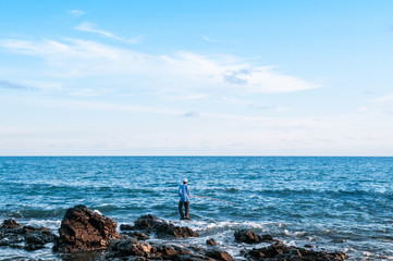 Wall Mural - Local fisherman is fishing with fishing rod in evening at Nui beach on Koh Lanta, Krabi, Thailand