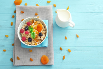 Wall Mural - Tasty oatmeal with berries and fruit in bowl on table