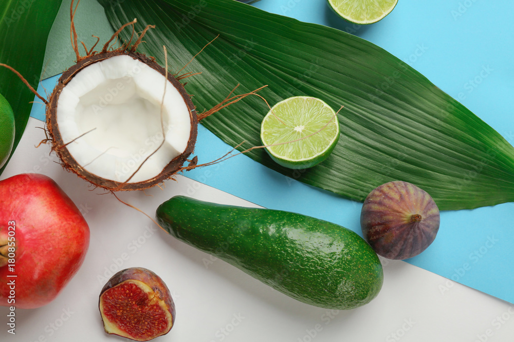 Composition with tropical leaves and exotic fruits on color background