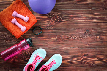 Wall Mural - Composition with towel and sport equipment on wooden background