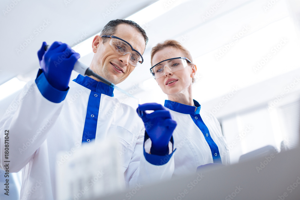 Laboratorian Look carefully. Beautiful laboratory assistant observing how ...
