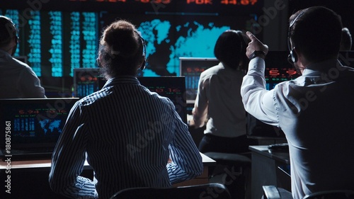 Fotografía Financial traders working in modern office analyzing statistics and driving trade on exchange