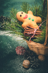 Wall Mural - Christmas card with gingerbread man and coniferous branches in basket