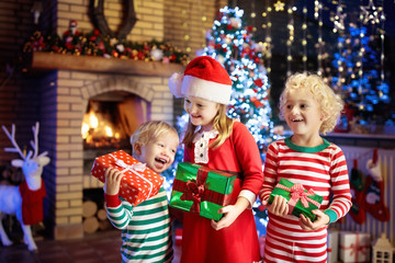 Wall Mural - Child at Christmas tree. Kids at fireplace on Xmas