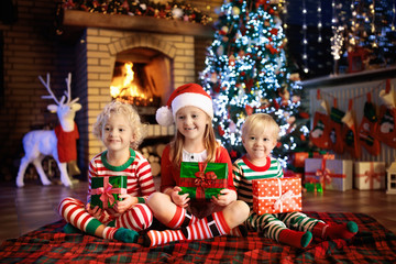 Wall Mural - Child at Christmas tree. Kids at fireplace on Xmas