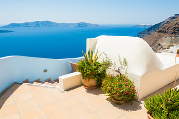  Santorini island, Greece. Beautiful terrace with flowers, sea view.
