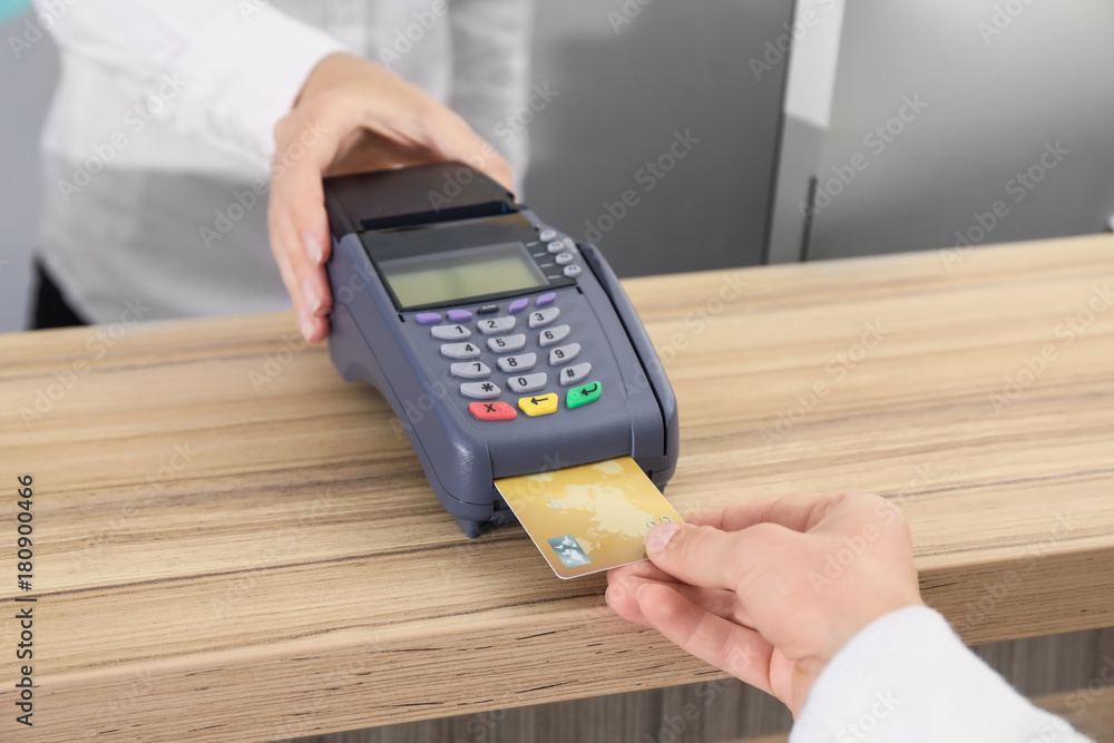 Woman using bank terminal for credit card payment indoors