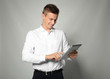 © Africa Studio - Attractive young manager with tablet on light background
