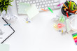 Clutter in office. Desk covered with crumpled paper and scattered stationery. White background top view copyspace
