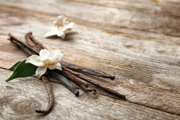 Sticker - Dried vanilla pods and flower on wooden background