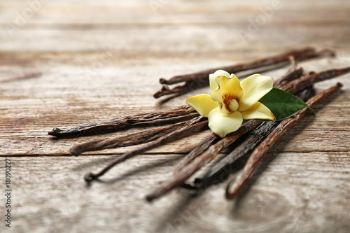 Fotografía Dried vanilla pods and flower on wooden background