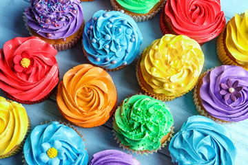 Wall Mural - Tasty colorful cupcakes on table