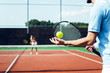 Exciting competition. Rear view of young couple playing tennis on the tennis court. 