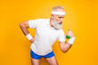 © deagreez - Body care, hobby, weight loss lifestyle. Cool grandpa with confident grimace exercising holding equipment up, lifts it with strength and power, wearing blue sexy shorts, show legs