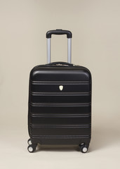 Black trolley suitcase bag isolated on beige background