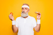 © deagreez - Athlete cool grandpa holds forbidden junkfood cheeseburger and fruit. Weightloss, decision, motivation, healthcare, strength, prohibition, workout, gym, regime, bodycare, calories lifestyle