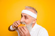 © deagreez - Weightloss, healthcare, gym, strength, regime, challenge. Close up of modern athlete cool grey haired pensioner grandpa hold yummy tasty delicious heavy grossy sandwich, destroys it