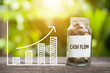 Cash Flow Word With Coin In Glass Jar and graph up. Financial Concept
