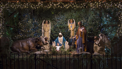 Christmas nativity scene with Mary, Joseph and angels looking down on baby Jesus in his manger