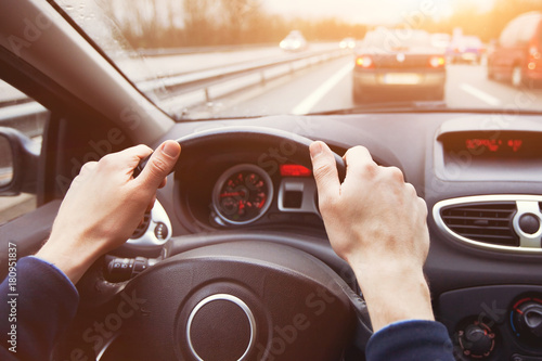 Fotomural traffic jam, driving car on highway, close up of hands on steering wheel in sunn