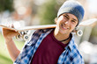 © Sergey Nivens - Teenage boy with skateboard standing outdoors