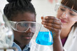 © highwaystarz - Female Pupil And Teacher Conducting Chemistry Experiment
