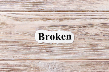 Wall Mural - BROKEN of the word on paper. concept. Words of BROKEN on a wooden background