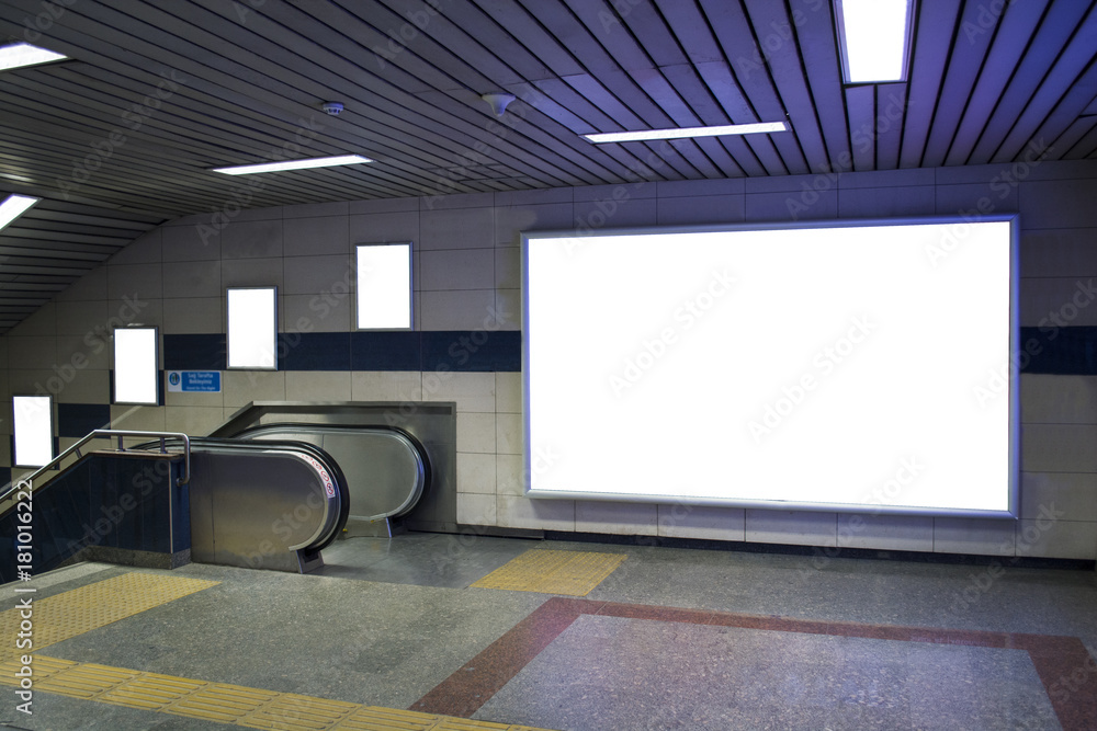 blank billboard beside escalator in subway useful for your advertising - obrazy, fototapety, plakaty 