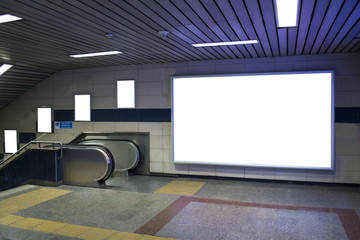 blank billboard beside escalator in subway useful for your advertising